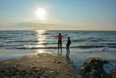 Scenic view of sea against sky, with two children 