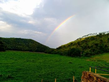 Scenic view of rainbow over mountains against sky