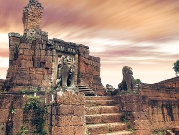 Statue of historic building against cloudy sky