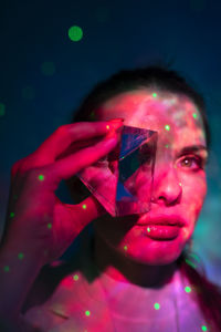 Close-up portrait of woman holding multi colored background