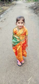 Portrait of cute girl standing on road