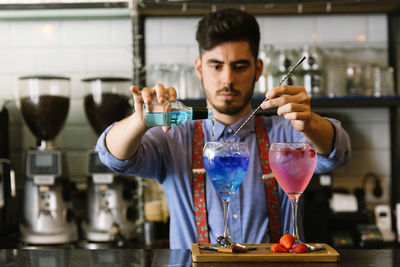 Midsection of bartender making drink