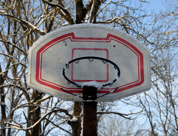 Low angle view of basketball hoop against sky during winter