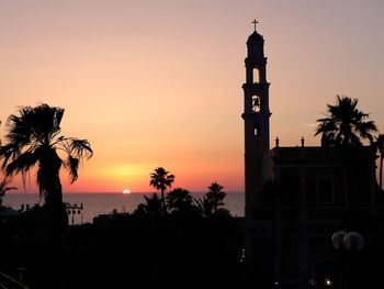 Silhouette of building against sky during sunset