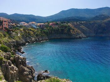 Scenic view of sea by buildings against sky