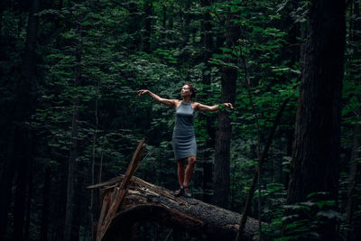 Woman with arms outstretched dancing on tree