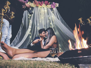 Young couple sitting on bonfire