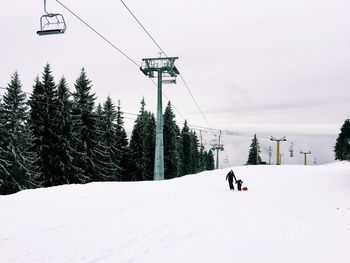 Low angle view of ski lifts on snowcapped mountain during winter