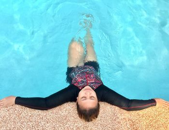 High angle view of woman relaxing in swimming pool