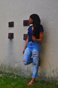 Full length of young woman standing by railing