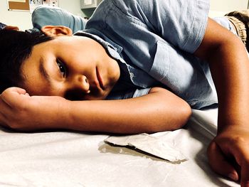 Portrait of cute boy lying on bed at home