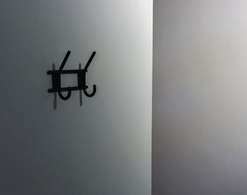 Close-up of silhouette cross on wall