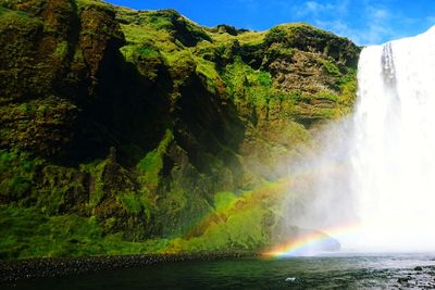 Scenic view of waterfall against sky