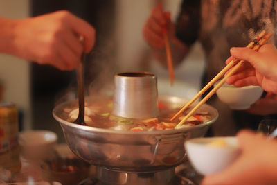 Cropped hand of people having chinese food with chopsticks