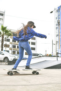 Side view of man skateboarding on street