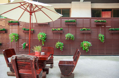 Empty chairs and tables against building