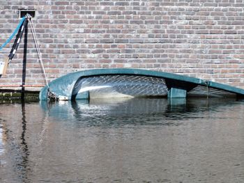 Arch bridge over river against wall