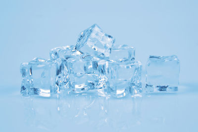 Stack of ice cubes on blue background