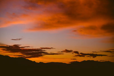 Scenic view of dramatic sky over silhouette landscape