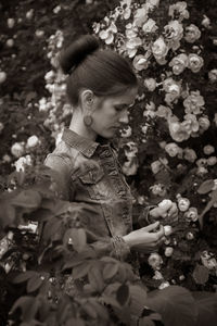 Low angle view of girl looking at flowering plants