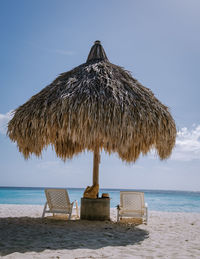 Thatched roof on beach against sky