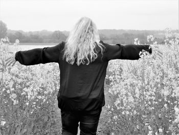 Rear view of woman standing on field