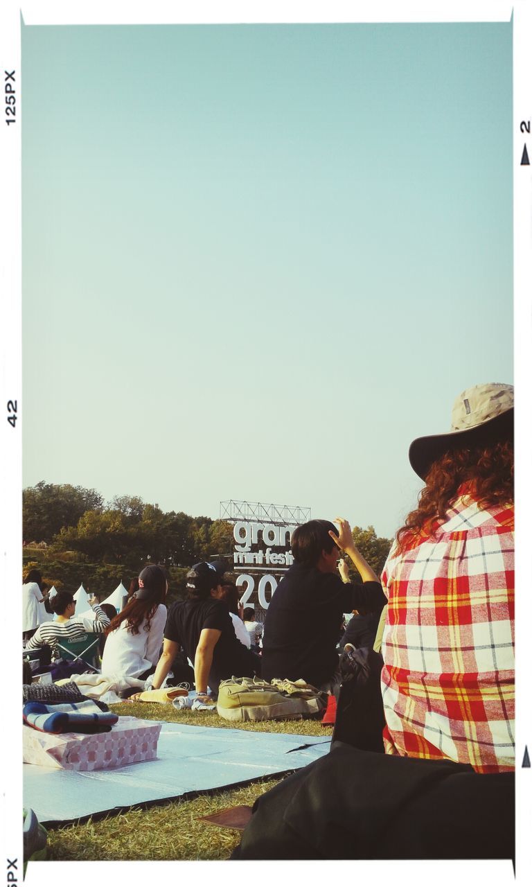 transfer print, clear sky, copy space, auto post production filter, men, lifestyles, blue, leisure activity, rear view, person, sitting, standing, day, outdoors, water, relaxation, rock - object