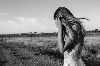 Woman standing on field against sky