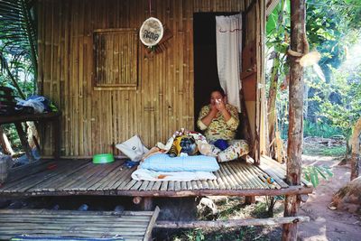 Woman with dog sitting in hut