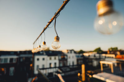 Close-up of illuminated light bulb against sky