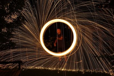 Man standing with wire wool at night