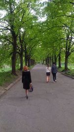 Rear view of people walking on footpath