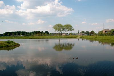 Scenic view of calm lake against cloudy sky