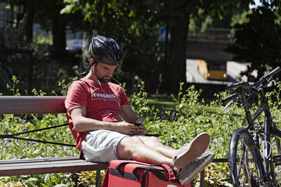 Full length of young man sitting on seat