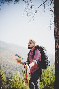 Full length of man standing by tree against sky