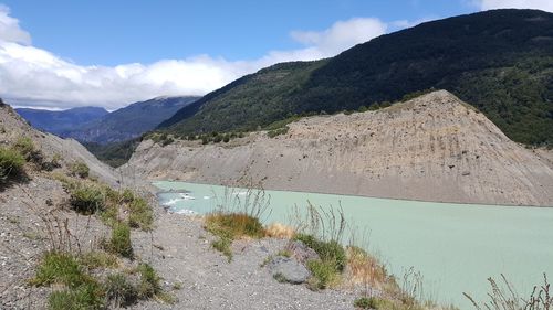 Scenic view of lake by mountains against sky