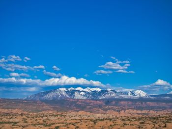 Scenic view of snowcapped mountains against blue sky