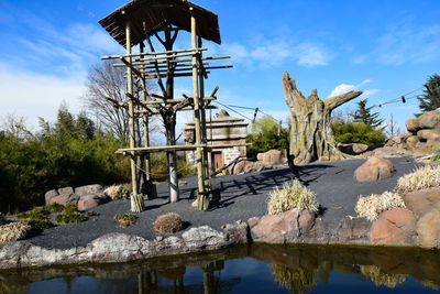 Gazebo on rock by lake against sky