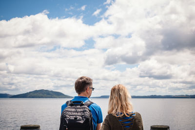 Rear view of people looking at sea against sky