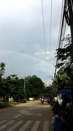 Cars on road against rainbow in city