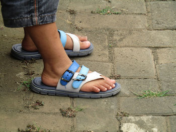 Low section of woman standing on footpath