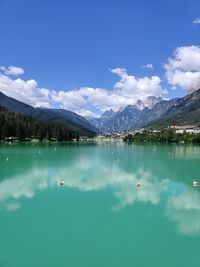 Scenic view of lake and mountains against blue sky