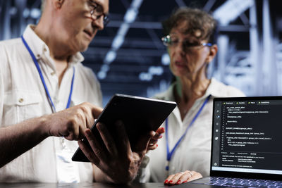 Midsection of man using digital tablet in office