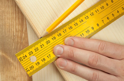 Close-up of carpenter taking measurement of wood