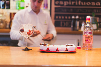 Midsection of bartender preparing drink at counter