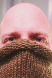 Close-up of man covering face with sweater