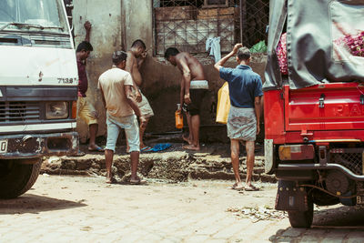 Rear view of people working on street in city