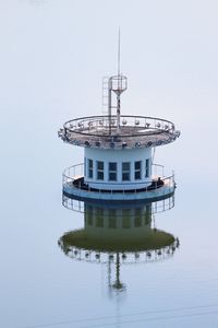 View of tower by lake against sky