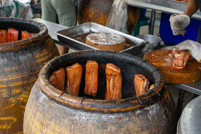 Barbecue ceramic pot with crispy pork belly inside in a thai restaurant