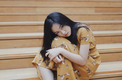 Sad young woman sitting on staircase